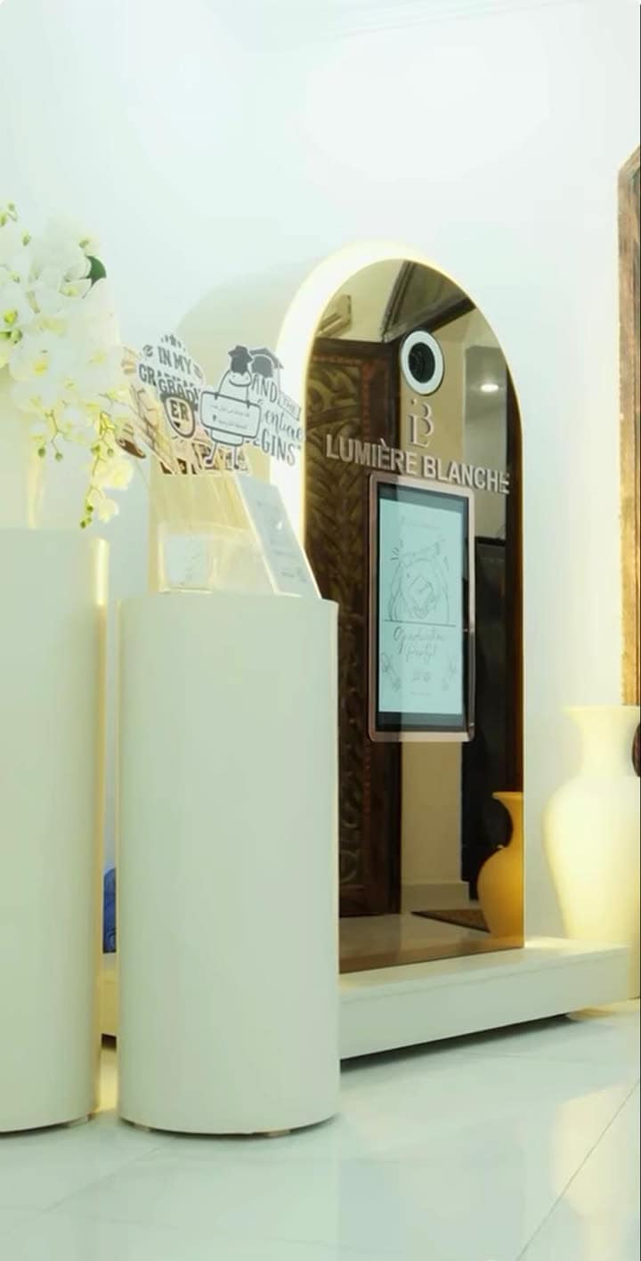 The Lumière Blanche arched mirror photo booth with a touchscreen, styled for a graduation party